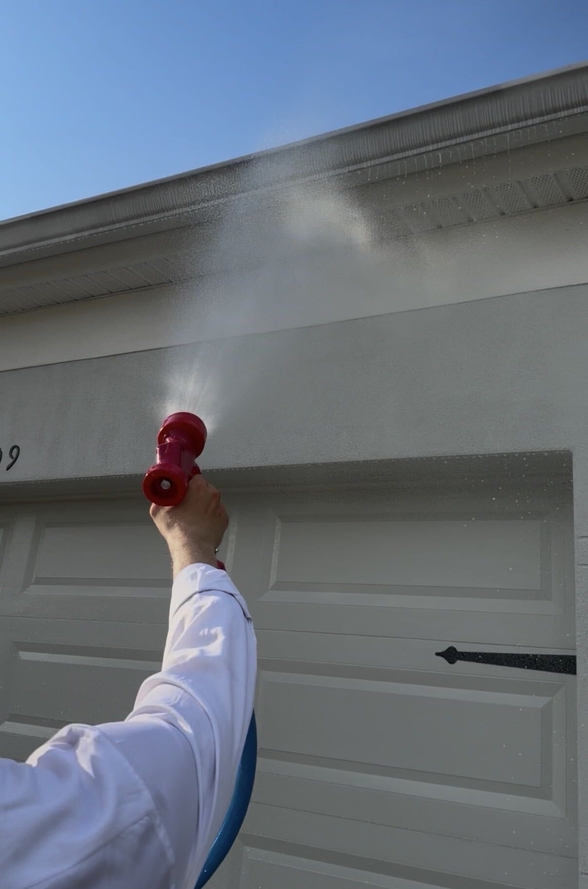 Exterior fascia being cleaned with a spray nozzle